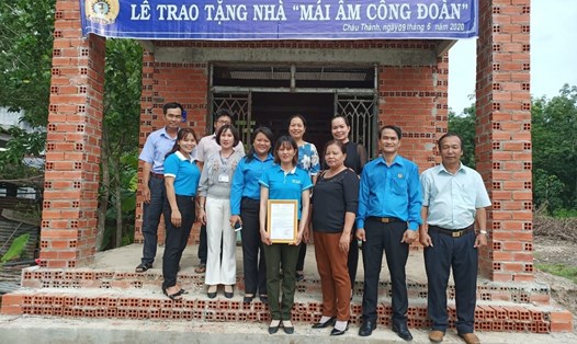 Các đại biểu chụp ảnh lưu niệm với gia đình chị Lê Thị Bé.