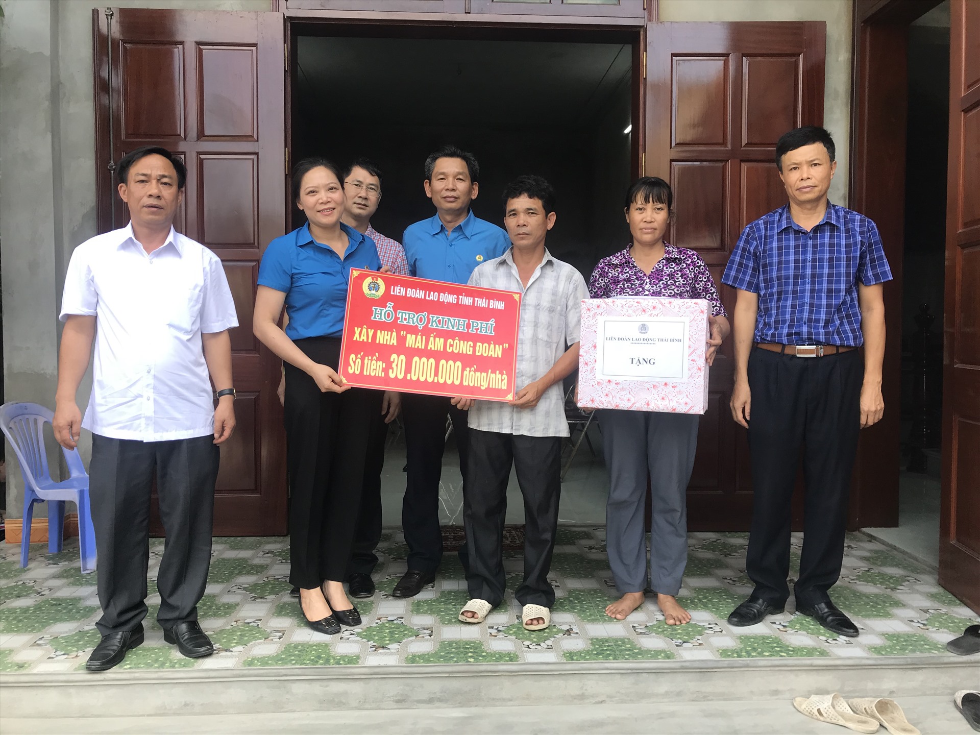 Lãnh đạo LĐLĐ tỉnh, công đoàn ngành, công đoàn công ty, lãnh đạo xí nghiệp trao kinh phí hỗ trợ và tặng quà cho vợ, chồng đoàn viên Nguyễn Văn Kha trong ngày khánh thành nhà mới. Ảnh: Bá Mạnh