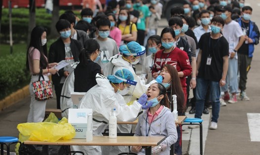 Nhân viên y tế lấy mẫu bệnh phẩm xét nghiệm COVID-19 của nhân viên 1 nhà máy ở Vũ Hán, Trung Quốc hôm 15.5. Ảnh: AFP.
