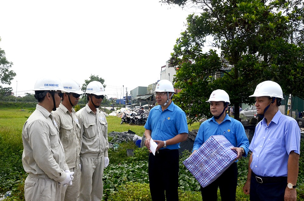 Phó Chủ tịch Công đoàn Điện lực Việt Nam Đỗ Đức Hùng (thứ ba từ phải sang) động viên người lao động khi phải làm việc dưới thời tiết nắng nóng. Ảnh: Thanh Huyền