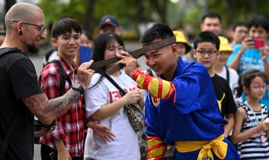 Một khán giả chạm vào thanh sắt được uống cong bằng sức mạnh của võ sinh thuộc môn phái Thiên Môn Đạo ở Hồ Hoàn Kiếm, Hà Nội. Ảnh: AFP