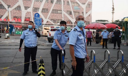 Cảnh sát Trung Quốc chặn lối vào chợ bán buôn thịt Xinfadi ở Bắc Kinh hôm 12.6. Ảnh: AFP.