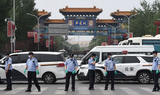 Cảnh sát đứng gác ở cổng chợ Tân Phát Địa ngày 13.6.2020. Ảnh: AFP