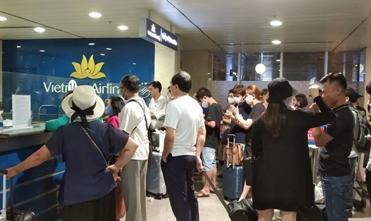Hành khách xếp hàng chờ làm thủ tục ở sân bay Tân Sơn Nhất tối ngày 14.6.  Ảnh: Chân Phúc