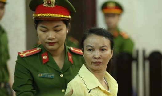 Lực lượng cảnh sát dẫn giải bị cáo Trần Thị Hiền (áo vàng) vào phòng xử. Ảnh: Việt Dũng.
