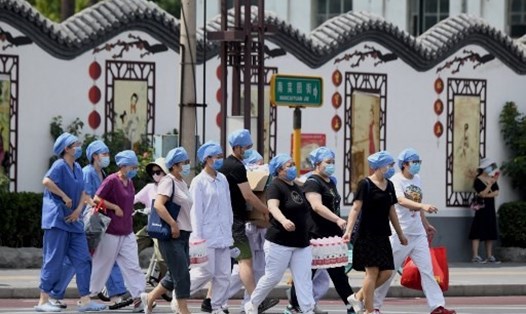 Nhân viên y tế đến chợ Xinfadi ở quận Phong Đài, Bắc Kinh để kiểm dịch COVID-19. Ảnh: AFP