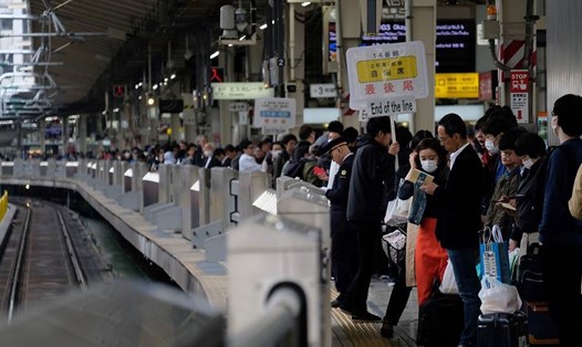 Hành khách đang đứng đợi tàu tại ga đường sắt Tokyo ngày 27.4. Ảnh: AFP