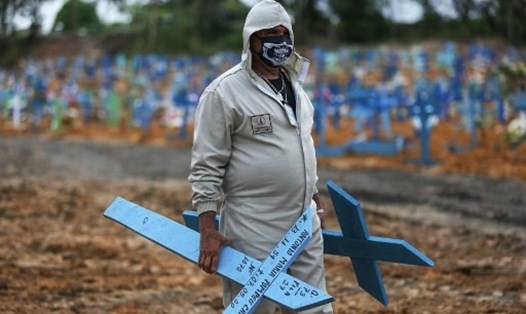 Ông Ulisses Xavier, 52 tuổi, đã làm việc 16 năm tại nghĩa trang Nossa Senhora ở Manaus, Brazil, chuẩn bị đặt những cây thánh giá lên những ngôi mộ trong ca làm việc của mình khi đại dịch COVID-19 bùng phát ở nước này. Ảnh: AFP.