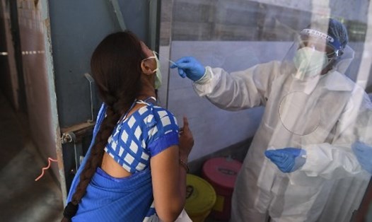 Nhân viên y tế lấy mẫu xét nghiệm COVID-19 cho người dân tại trung tâm xét nghiệm ngày 19.6, sau khi Chính phủ nới lỏng hạn chế lây lan bệnh dịch. Ảnh: AFP
