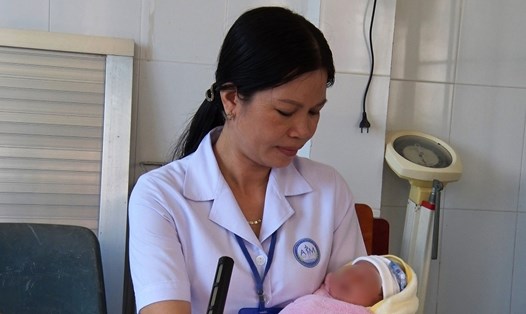 Cán bộ y tế của Trạm y tế xã Vân Khánh(huyện An Minh) chăm sóc bé gái bị bỏ rơi. Ảnh: N.A