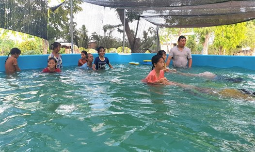 Thầy giáo trường THCS Ngô Mây (huyện Cư M’Gar, Đắk Lắk) dạy bơi cho các em học sinh trong mùa hè. Ảnh: Bảo Trung