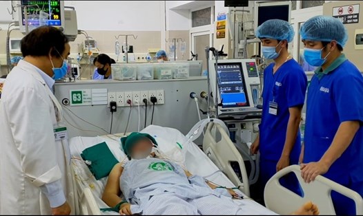 PGS.TS.BS Nguyễn Văn Chi (bên trái) đang thăm khám và hội chẩn tại giường cho một bệnh nhân nặng điều trị tại Khoa Cấp cứu A9. Ảnh: Mai Thanh.