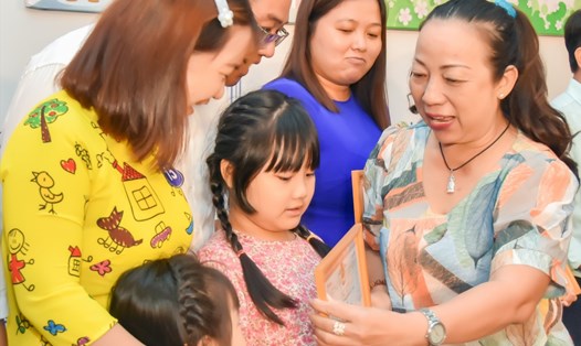 Bà Võ Thị Minh Phượng, Phó Trưởng ban Nữ công LĐLĐ TPHCM trao Giấy khen của LĐLĐ quận cho gia đình CNVCLĐ văn hóa, hạnh phúc tiêu biểu. Ảnh: Đức Long