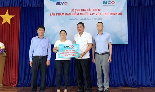 Ông Trần Hoài An, Tổng Giám đốc BIC và ông Nguyễn Bách Thọ, Giám đốc BIDV Quảng Nam, trao quyền lợi bảo hiểm cho đại diện gia đình khách hàng Đinh Văn Bạn