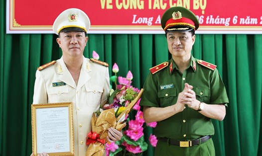 Thiếu tướng Nguyễn Duy Ngọc - Thứ trưởng Bộ Công an - trao Quyết định và tặng hoa chúc mừng Đại tá Lâm Minh Hồng. Ảnh: T.N