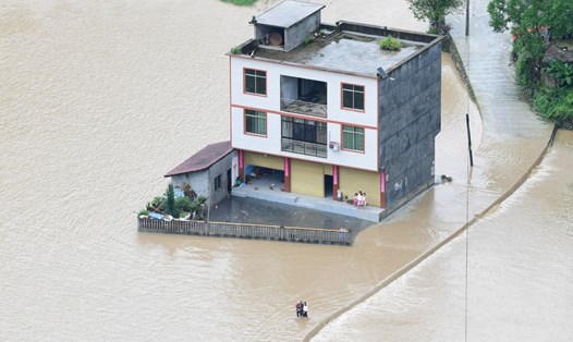 Dân làng sơ tán khỏi những ngôi nhà bị ngập lụt ở Trùng Khánh, Trung Quốc. Ảnh: Tân Hoa Xã