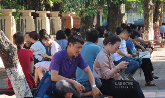 Phụ huynh mệt mỏi ngồi chờ con thi vào lớp 6 Trường THCS ngoại ngữ (Đại học Quốc gia Hà Nội) vào ngày 27.6. Ảnh: Sở Hạ