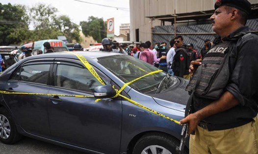 Một cảnh sát canh gác bên chiếc xe 4 tay súng đã sử dụng trong vụ tấn công vào sàn giao dịch chứng khoán ở Karachi. Ảnh: AFP.