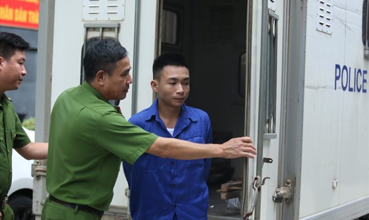 Bị cáo Đinh Văn Giáp (áo xanh công nhân, bên phải) bị dẫn giải vào phòng xử.