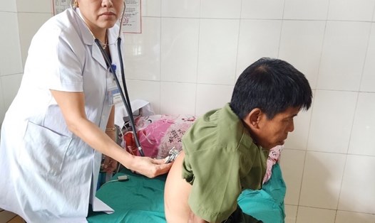 Bà Vũ Thị Kim Ngân - Chủ tịch CĐCS Trung tâm Y tế huyện khám chữa bệnh cho bệnh nhân. Ảnh: Trần Nga