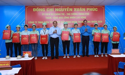 Thủ tướng Nguyễn Xuân Phúc và Chủ tịch Tổng LĐLĐVN Nguyễn Đình Khang trao quà cho công nhân lao động. Ảnh: Hải Nguyễn