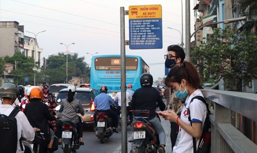 Người dân phải đội nắng, mưa chờ xe buýt tại một điểm dừng đỗ trên đường Nguyễn Khoái (Hà Nội). Ảnh: ANH THƯ - ĐỨC CHÁNH