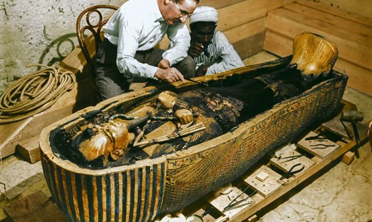 Nhà khảo cổ Howard Carter mở quan tài bằng vàng nguyên khối quàn thi hài vua Tut trong bức ảnh phục dựng màu. Ảnh: Viện Griffith