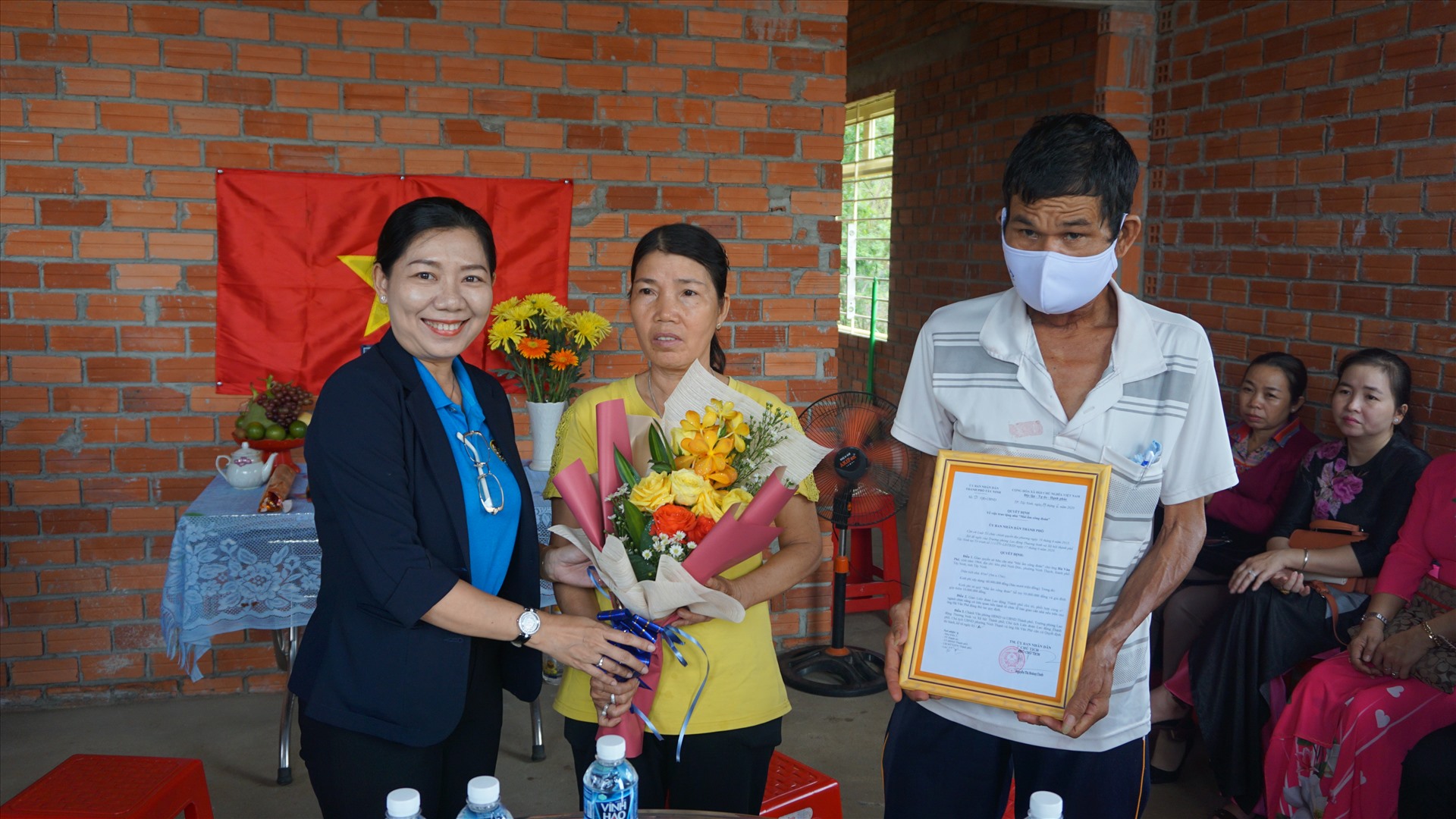 Bà Đinh Thị Dương Thúy - Chủ tịch LĐLĐ thành phố Tây Ninh trao Quyết định tặng nhà cho vợ chồng anh Phê.