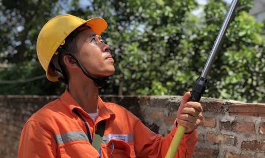 Nhân viên EVN Hà Nội đi kiểm tra chỉ số công tơ điện tại huyện Mê Linh. Ảnh: C.Ngô