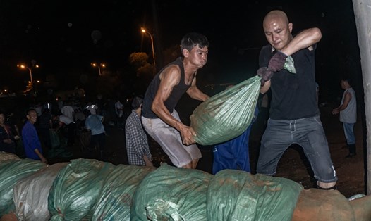 Người dân đặt bao cát trên các đê bao trong đêm phòng nước lũ dâng cao ở huyện Bà Dương, tỉnh Giang Tây, Trung Quốc. Ảnh: Thời báo Hoàn cầu.