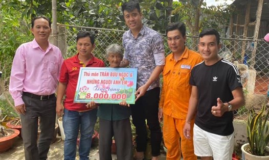 Thủ môn Trần Bửu Ngọc (giữa) trao tặng số tiền anh quyên góp được cho cụ bà Nguyễn Thị Hái. Ảnh: NVCC