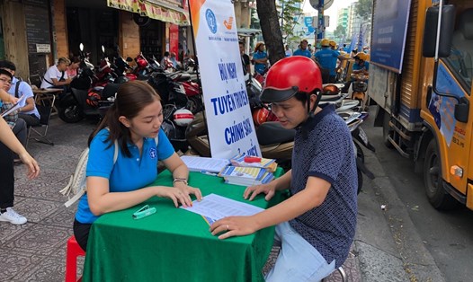Cán bộ Bảo hiểm xã hội (BHXH) TP.Hồ Chí Minh tuyên truyền chính sách BHXH 
tự nguyện, bảo hiểm y tế hộ gia đình tới người dân. Ảnh: H.A