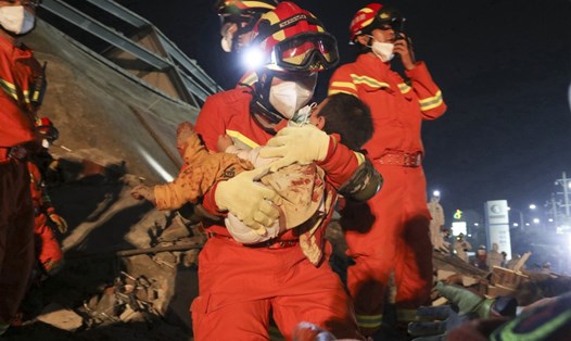 Một nhân viên cứu hộ cứu đứa bé khỏi đống đổ nát sau khi khách sạn bị sập ở tỉnh Phúc Kiến, Trung Quốc vào tháng 3.2020. Ảnh: China Daily