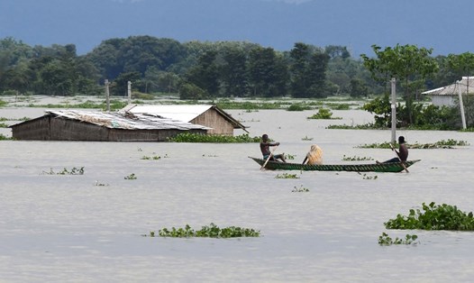 Dân làng di chuyển bằng thuyền tại khu vực bị ảnh hưởng lũ lụt bang Assam, Ấn Độ hôm 14.7. Ảnh: AFP.