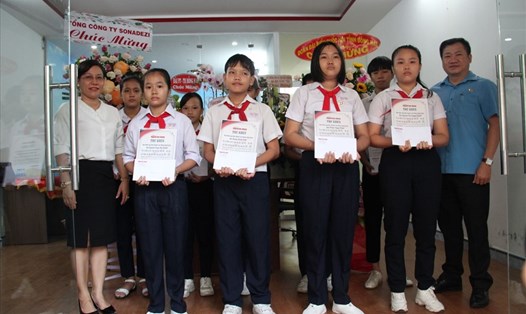 Phó Chủ tịch LĐLĐ tỉnh Đồng Nai Tăng Quốc Lập trao thư khen và học bổng cho các em học sinh vượt khó học giỏi. Ảnh: Minh Châu