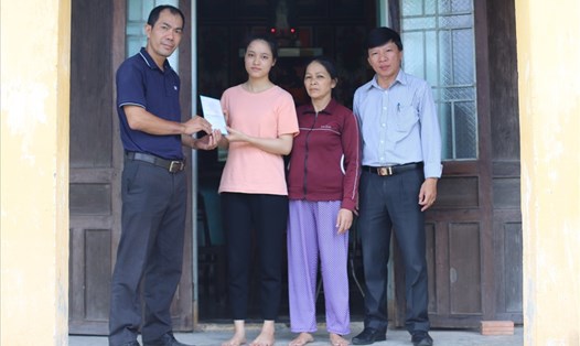 Đại diện Báo Lao Động tại miền Trung - Tây Nguyên trao 1 cuốn sổ tiết kiểm trị giá 10 triệu đồng cho em Nguyễn Thanh Thúy.