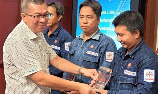Ông Nguyễn Văn Thanh, Tổng Giám đốc EVNHCMC trao biểu trưng tuyên dương các gương "Người công nhân ưu tú ngành điện thành phố mang tên Bác". Ảnh Nam Dương