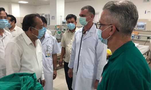 Phó Thủ tướng Thường trực Trương Hoà Bình (bên trái) trao đổi với các chuyên gia Cu Ba về tình hình cứu chữa các nạn nhân. Ảnh: Lê Phi Long