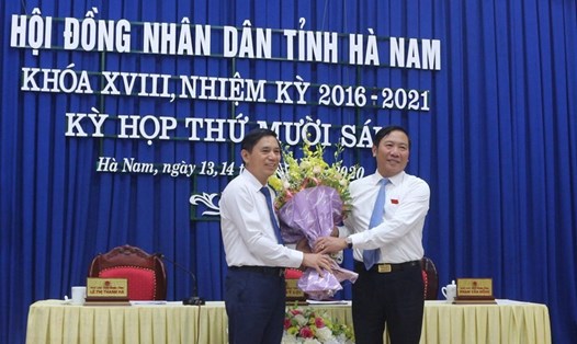 Ông Phạm Sỹ Lợi, Phó Bí thư thường trực Tỉnh ủy, Chủ tịch HĐND tỉnh Hà Nam tặng hoa chúc mừng ông Trần Xuân Dưỡng. Ảnh: TTXVN.