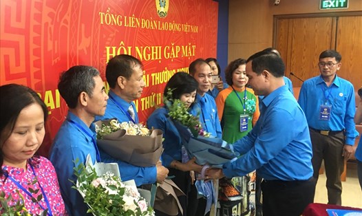 Đồng chí Nguyễn Đình Khang tặng hoa chúc mừng 10 cán bộ công đoàn được nhận Giải thưởng Nguyễn Văn Linh. Ảnh: Quỳnh Hân