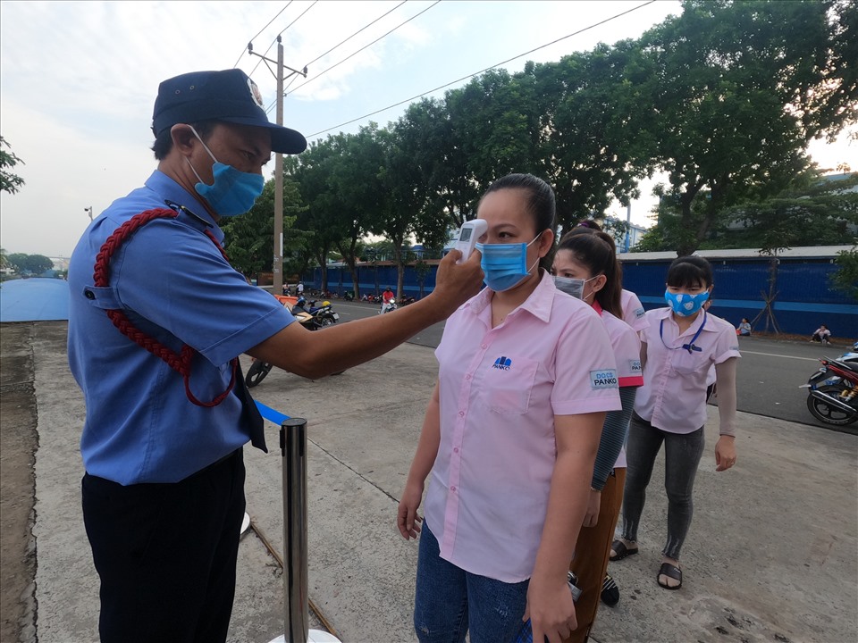 Kiểm tra thân nhiệt công nhân trước khi vào nhà xưởng. Ảnh: Đình Trọng