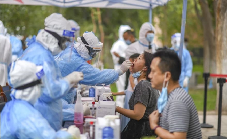 Nhân viên y tế thu thập mẫu bệnh phẩm xét nghiệm COVID-19 cho người dân tại Tân Cương, Trung Quốc hôm 20.7. Ảnh: Tân Hoa Xã.