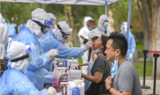 Nhân viên y tế thu thập mẫu bệnh phẩm xét nghiệm COVID-19 cho người dân tại Tân Cương, Trung Quốc hôm 20.7. Ảnh: Tân Hoa Xã.
