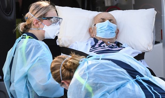 Nhân viên y tế ở Melbourne, Australia, vận chuyển một bệnh nhân khi thành phố đối mặt với đợt bùng phát COVID-19 mới. Ảnh: AFP