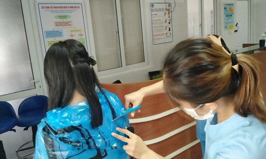 Các y bác sĩ tại Bệnh viện Đà Nẵng cắt tóc cho nhau để tiện lợi cho việc chống dịch. Ảnh: Ngọc