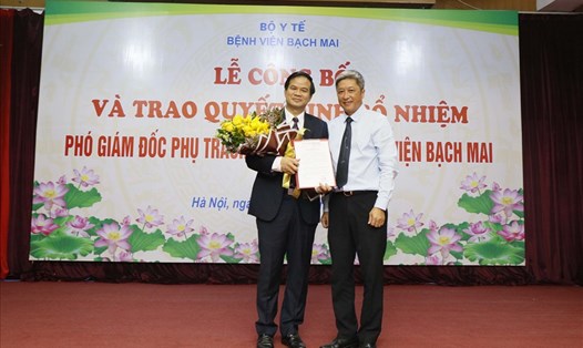 Thứ trưởng Bộ Y tế Nguyễn Trường Sơn (áo xanh) trao quyết định và tặng hoa chúc mừng PGS.TS Đào Xuân Cơ. Ảnh: Mai Thanh.