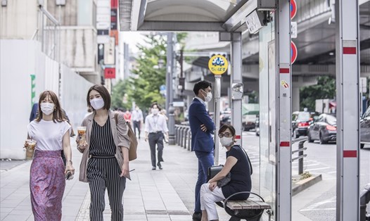 Người đi bộ đeo khẩu trang ở Tokyo, Nhật Bản hôm 30.7. Ảnh: Bloomberg/Getty.