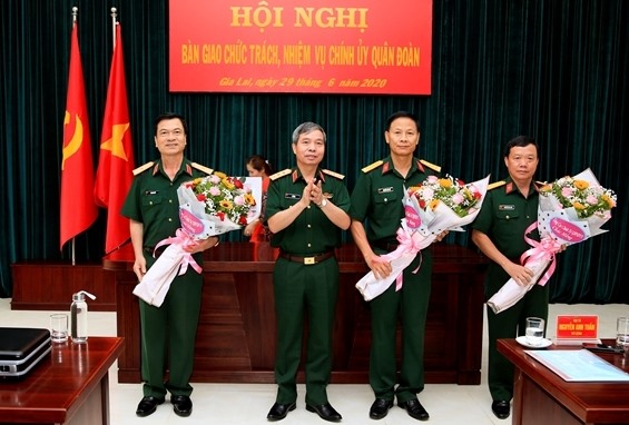 Thượng tướng Đỗ Căn trao quyết định và chúc mừng các cán bộ được bổ nhiệm chức vụ mới. Ảnh BQP