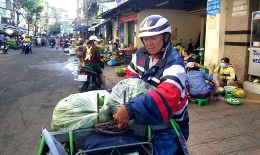 Mỗi ngày, anh Trần Quốc Việt đều chạy xe máy ra chợ Tân An để chở rau củ quả của tiểu thương tặng đến các ngôi chùa, bếp ăn từ thiện. Ảnh: N.T