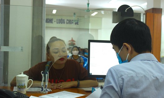 Cán bộ Trung tâm dịch vụ việc làm Hà Nội hướng dẫn người lao động làm thủ tục hưởng bảo hiểm thất nghiệp. Ảnh: Trần Kiều